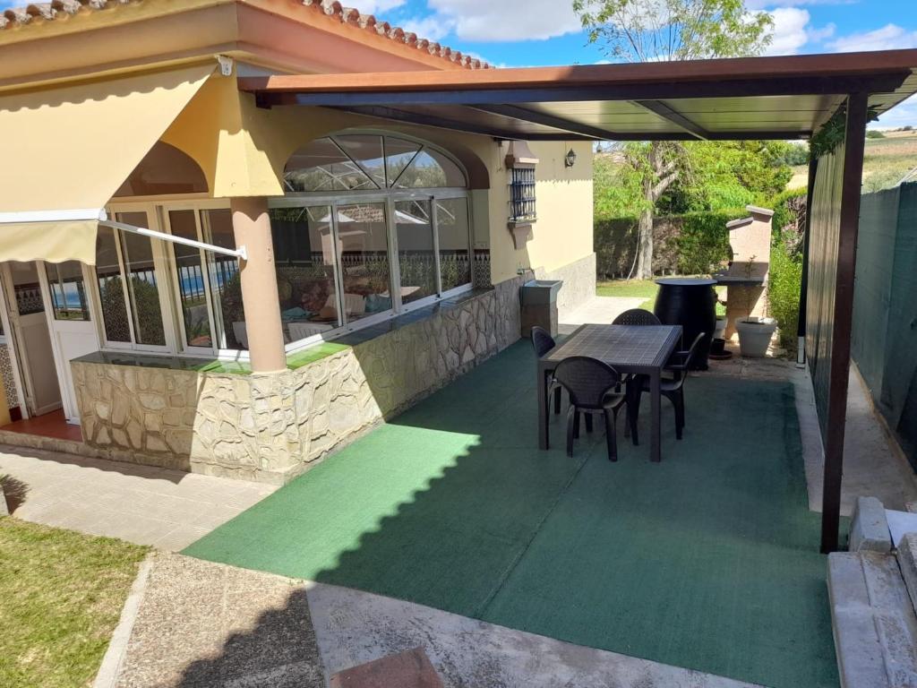 a patio with a table and chairs under a pergola at Casa La Laguneta in Arcos de la Frontera