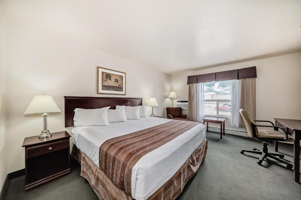 Postel nebo postele na pokoji v ubytování Grande Cache Inn & Suites