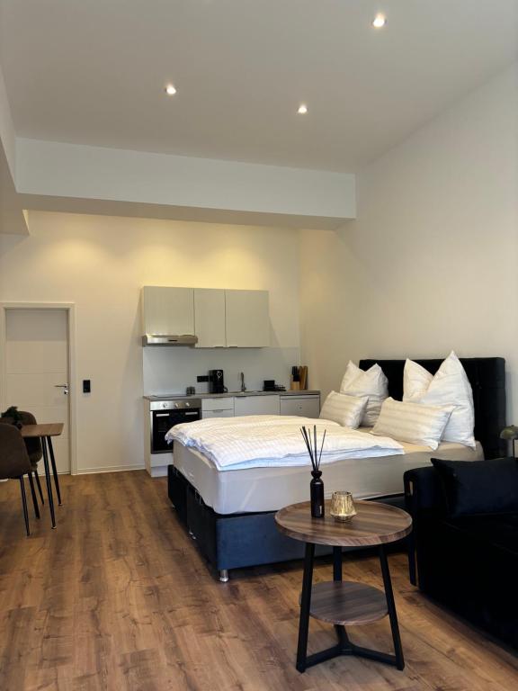 a bedroom with a large bed and a kitchen at Luxus Apartment mit Whirlpool in Kiel in Kiel