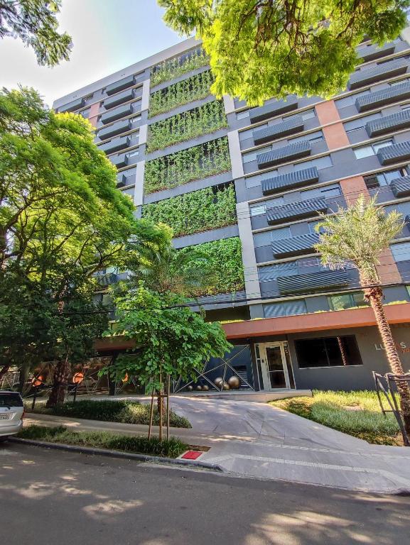 a tall building with trees in front of it at Lucas by Yoo por LikeHome in Auxiliadora