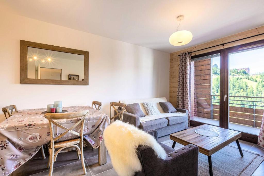 un salon avec une table et un canapé dans l'établissement Résidence Lodges 1970 - Résidence LES LODGES 1970 N° A407 MAE-1511, à La Plagne Tarentaise