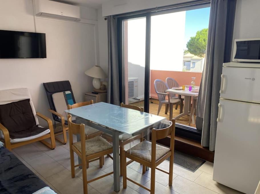 une cuisine et une salle à manger avec une table et des chaises dans l'établissement T2 avec piscine proche plage, au Cap d'Agde