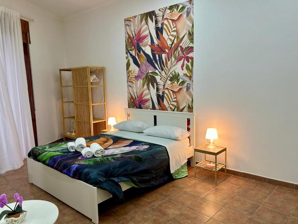een slaapkamer met een bed met een muurschildering van bloemen aan de muur bij MAISON PALU' in Napels