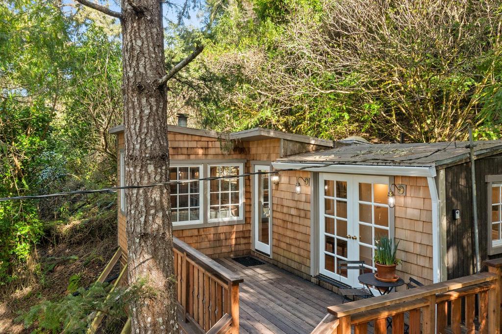 una piccola casa con terrazza e albero di Luxury Riverview Cottage - walk to town & trails a Duncans Mills