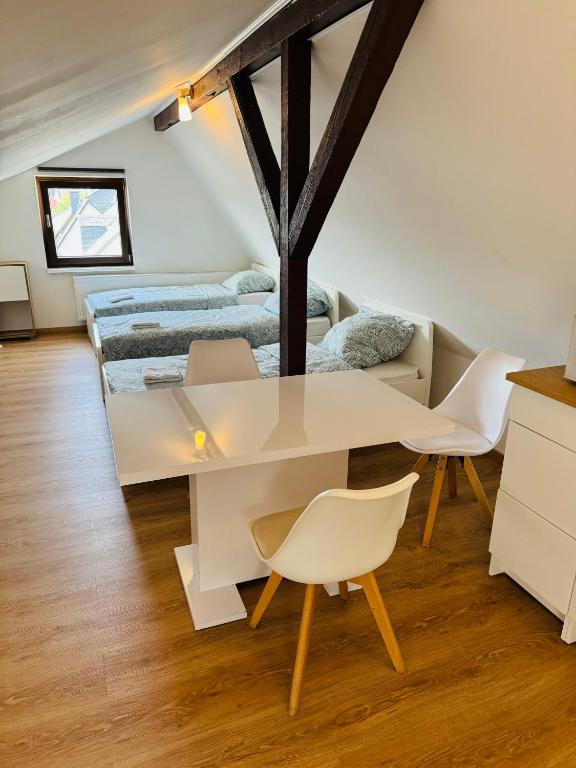 a white table and chairs in a room with a bed at Großzügiges Apartment am Rhein in Koblenz-Neuendorf in Koblenz
