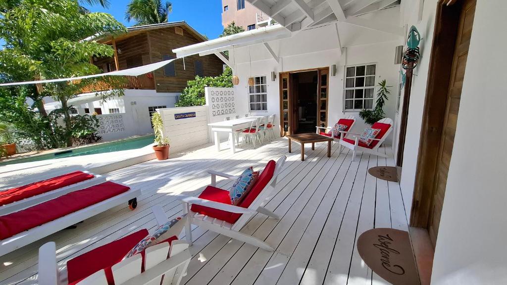 una terraza con sillas y una mesa en una casa en Amanda's Place Casita Carinosa - pool and tropical garden, en Caye Caulker