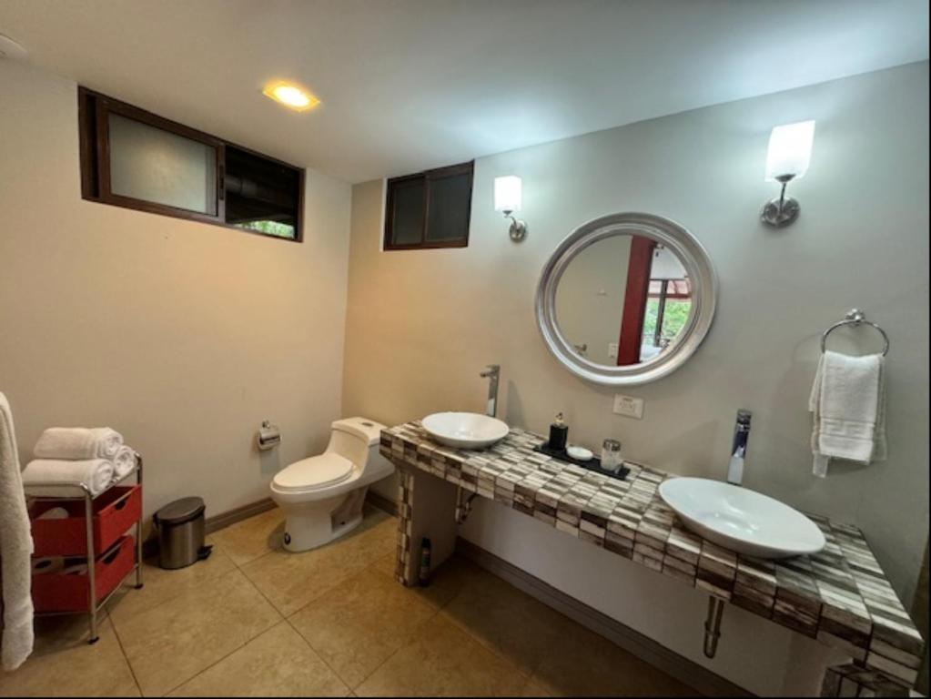 a bathroom with two sinks and a mirror and a toilet at Rancho Humo Estancia in Puerto Humo