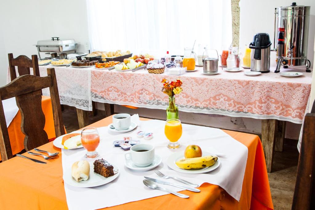 a table with plates of food and drinks on it at BemTeVi Em Búzios in Búzios