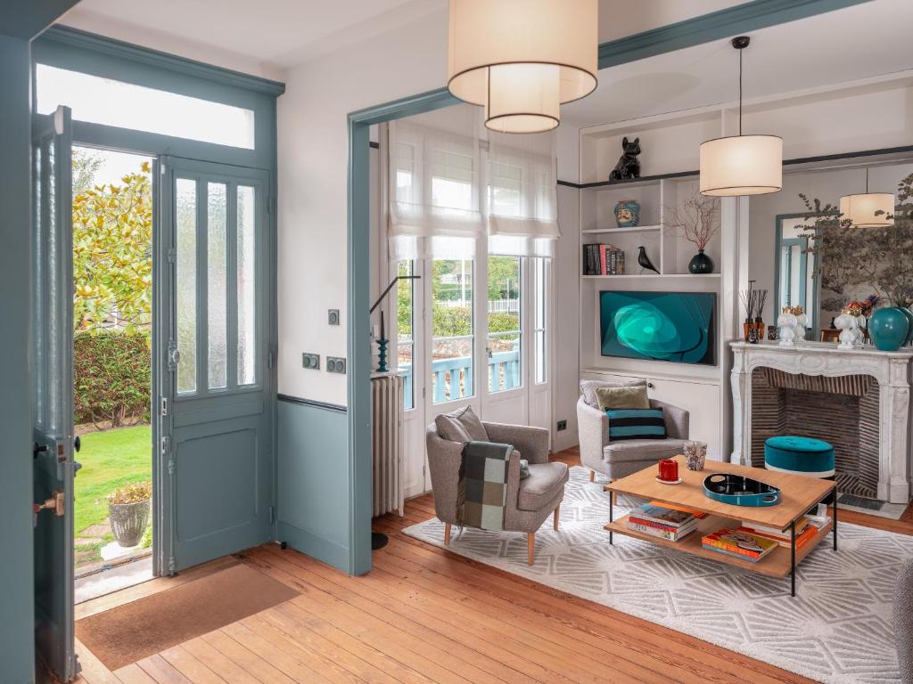 a living room with a blue door and a table at Villa Berry Centre Deauville - Chic & Stylée - Magnifique Jardin in Deauville