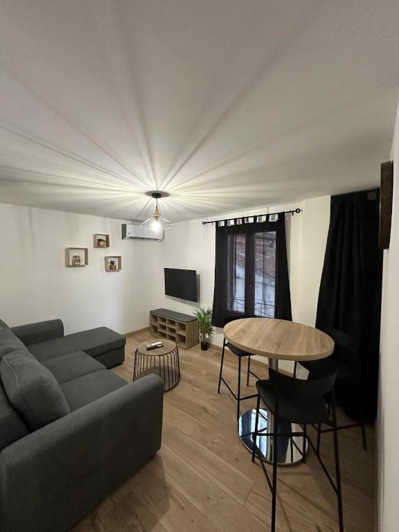 un salon avec un canapé et une table dans l'établissement Superbe appartement “l’Eden”Clim, proche remparts, à Avignon