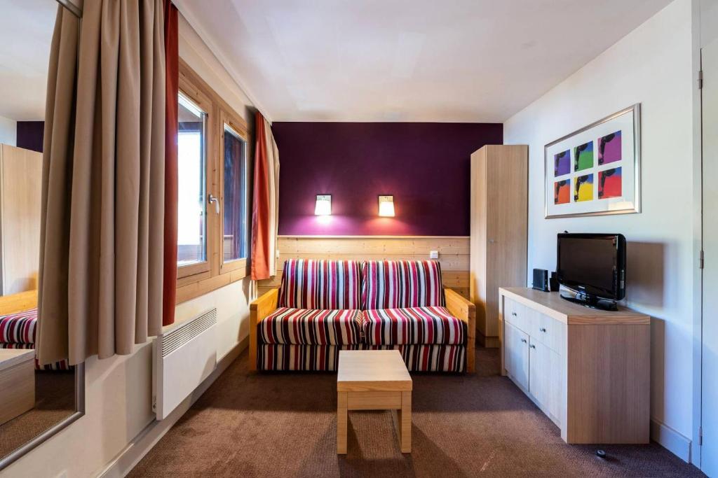 un salon avec un canapé et une télévision dans l'établissement Résidence Soldanelle - Résidence LES SOLDANELLE N°435 MAE-1711, à La Plagne Tarentaise