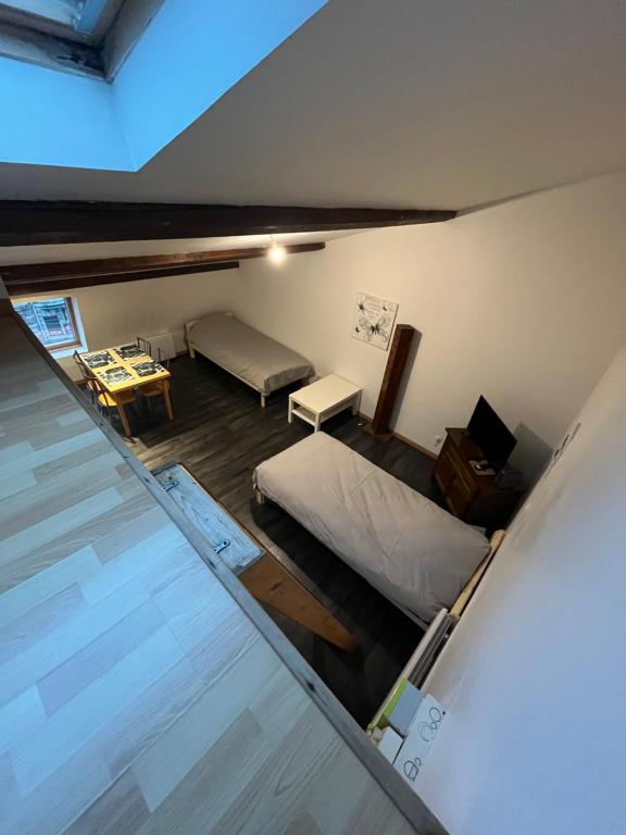 - une vue de tête sur une chambre avec un lit et une table dans l'établissement Le Thiers I, à Pont-à-Mousson