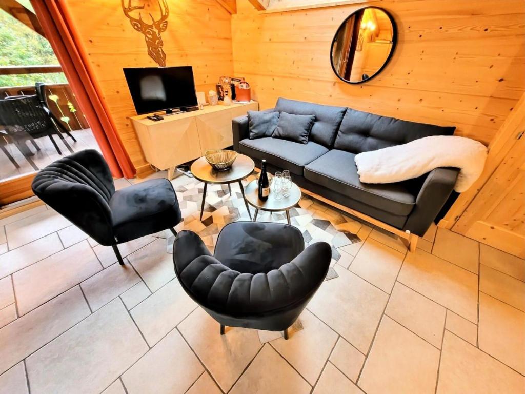un salon avec un canapé et des chaises dans l'établissement Résidence Le ChampÉ - Appartement paisible à deux pas du centre MAE-3701, aux Gets