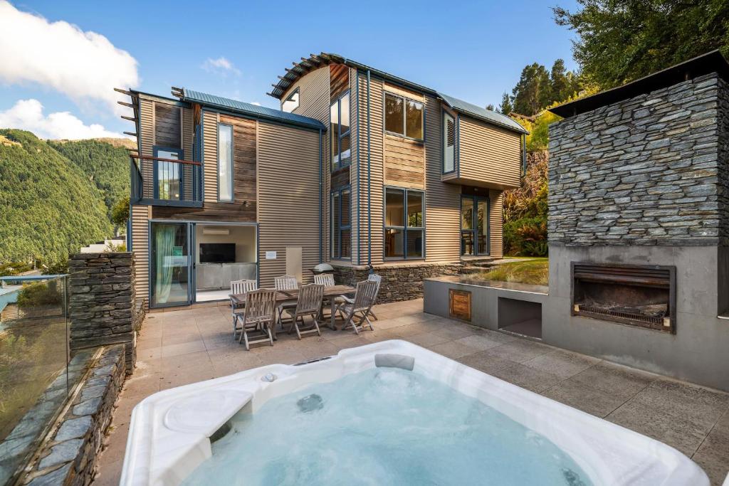 a house with a hot tub on a patio at Belfast Retreat - Views and Spa Pool in Queenstown