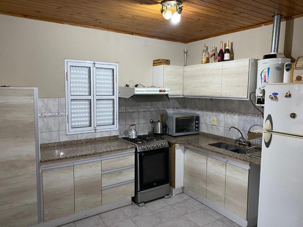 una cocina con estufa y refrigerador en Alquiler Villa Elisa, en Villa Elisa