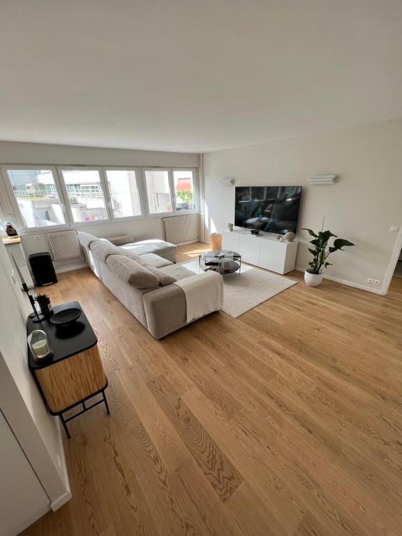 un salon avec un canapé et une télévision dans l'établissement Luxury apartment 16', à Paris
