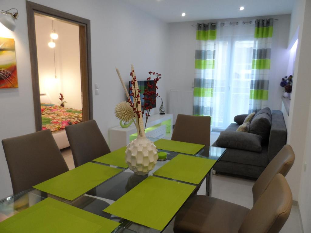 a dining room with a green table and chairs at Laura Deluxe Apartment in Thessaloniki