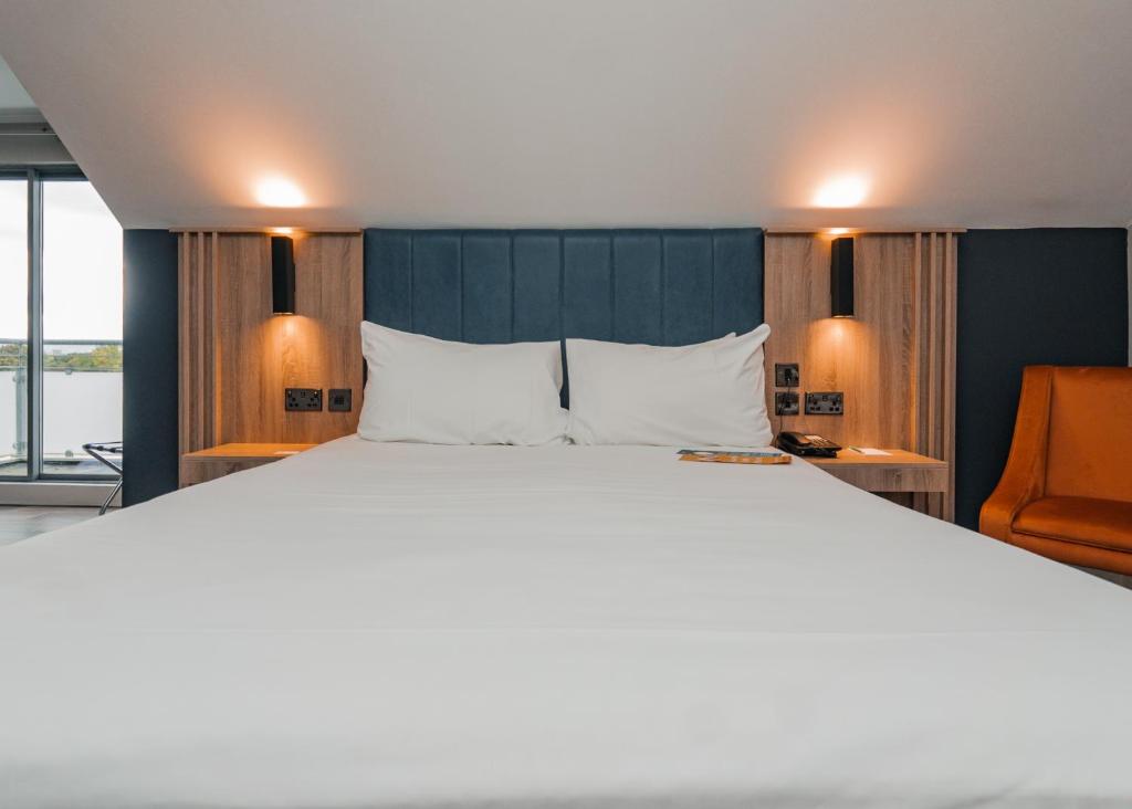 a bedroom with a large bed and a chair at Springfield Hotel in Leixlip