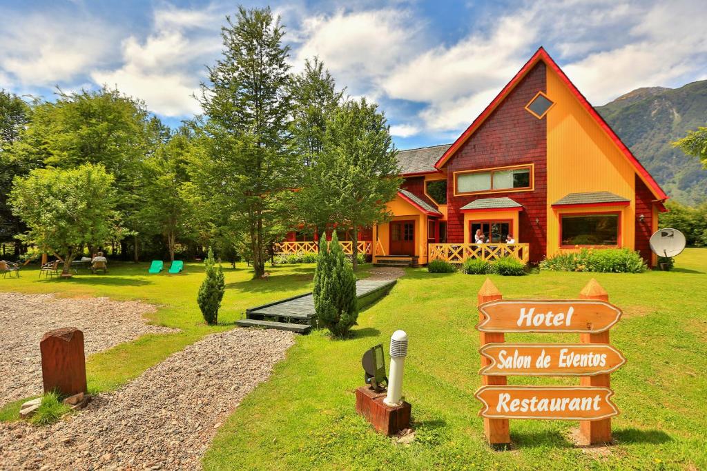 a house with a sign in front of it at Hotel y Cabañas Patagonia Green in Puerto Aisén