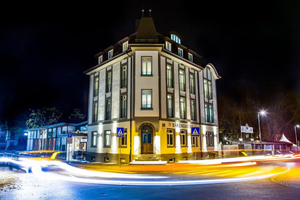 un grand bâtiment jaune dans une rue la nuit dans l'établissement Pucci Bärengarten Stadthotel, à Ravensbourg