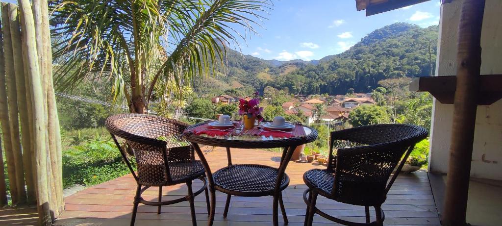 ルミアルにあるSerena Suíte Lumiarのテーブルと椅子4脚、景色を望むバルコニー