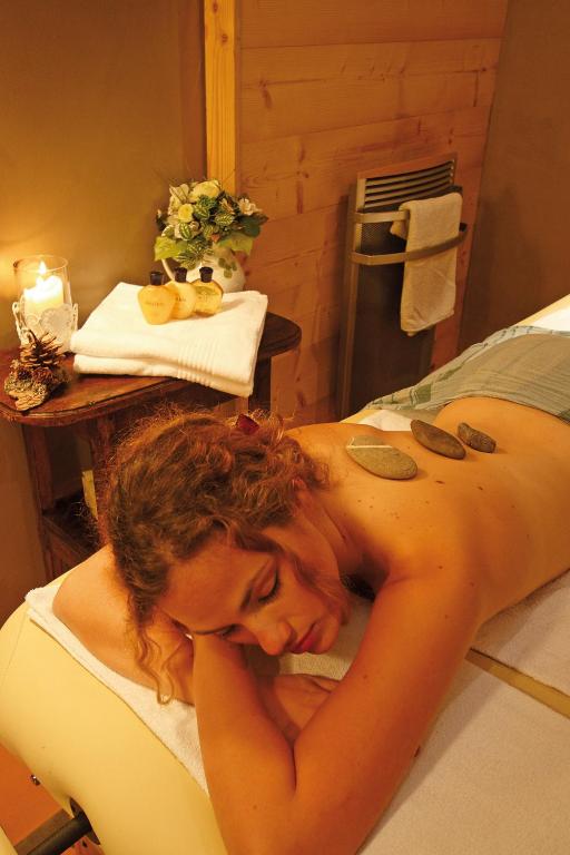 a woman laying on a bed in a room at Logis Hôtel et Spa Le Christiania in La Salle-les-Alpes