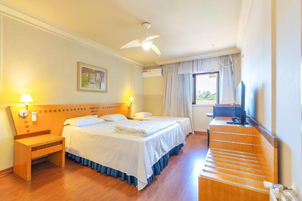 格拉玛多Suíte 453 Wish Serrano Resort Gramado的一间卧室，配有两张床和一台平板电视