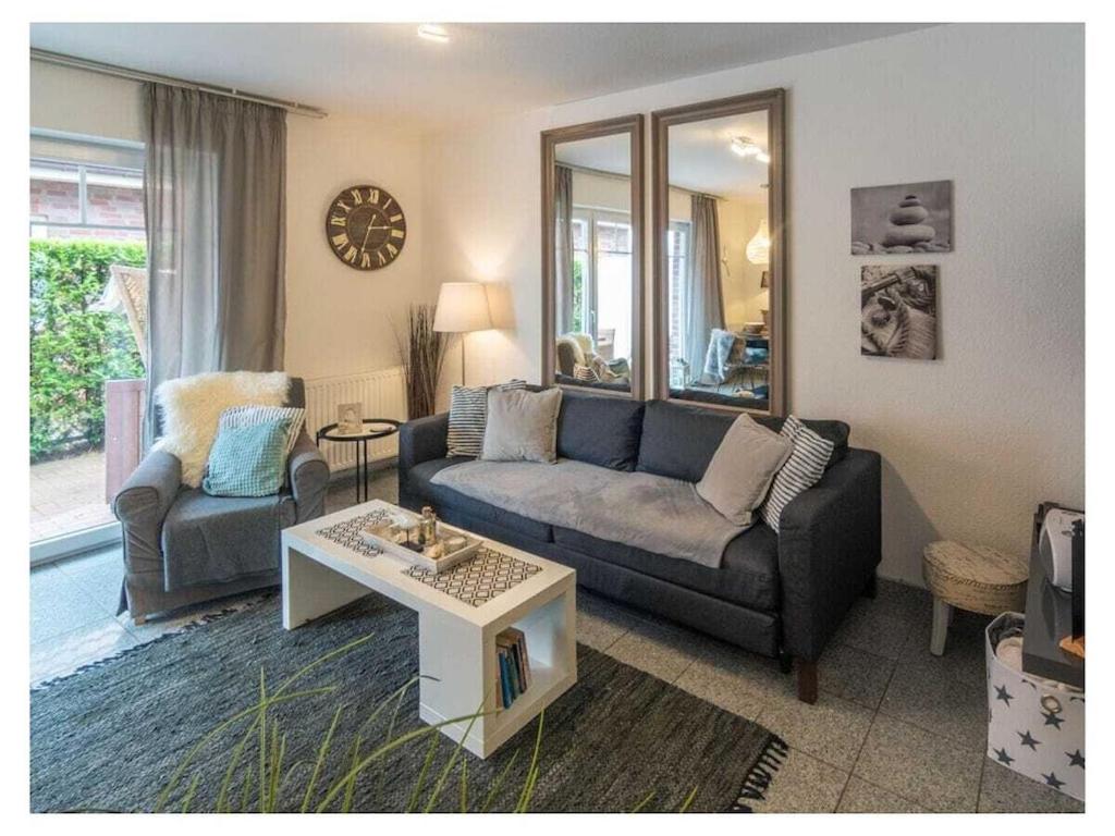 a living room with a couch and a table at Holiday Apartment Dünenrose in Norddeich