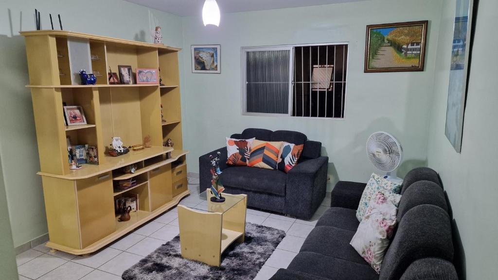 a living room with a couch and a chair at Apartamento da Tia Jaci in Paulista