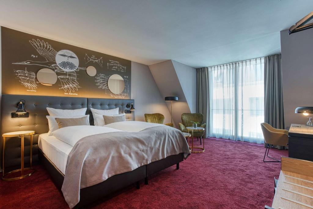 a bedroom with a large bed and a large window at Boutique by EMPA in Ulm