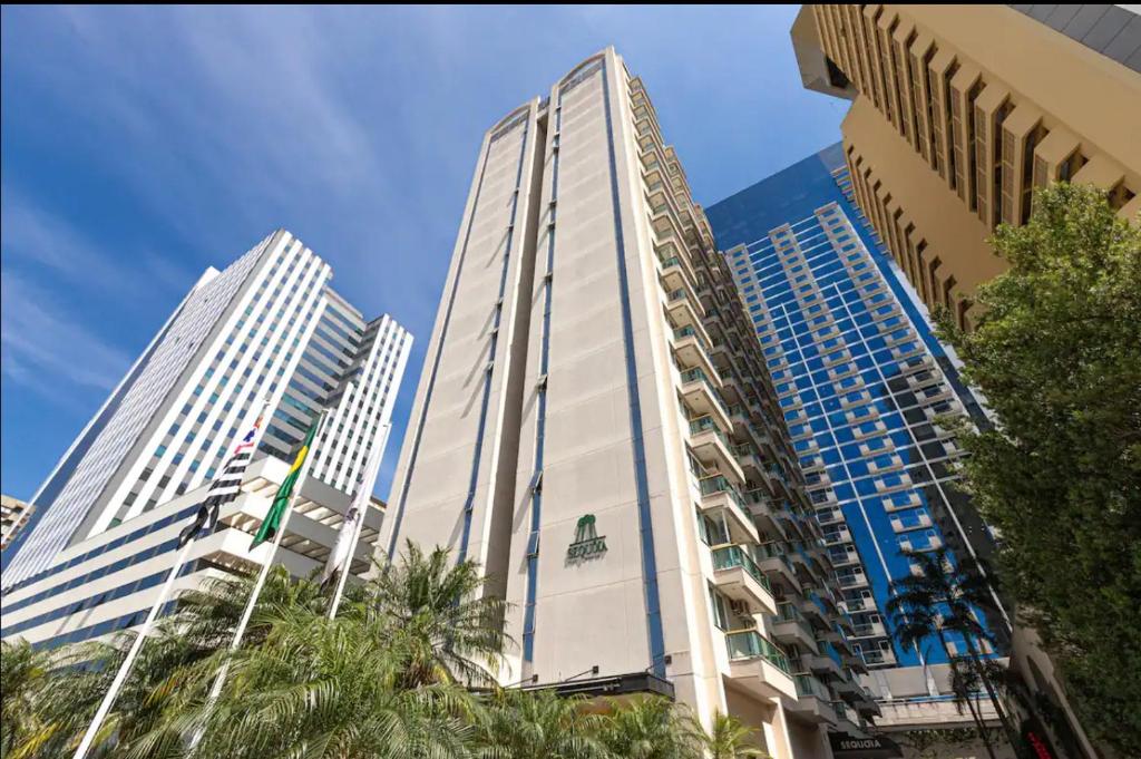 AldeiaHotel e Residencia Sequoia的棕榈树环绕的城市中有两栋高楼
