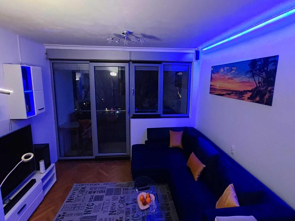 ein blaues Wohnzimmer mit einem Sofa und einem TV in der Unterkunft Apartment Sunrise in Dugi Rat