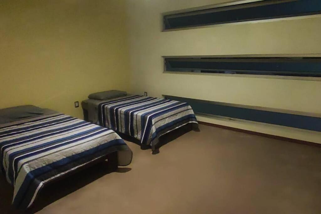 a room with two beds and a window at Comodidad y Confort en Morelia in Morelia
