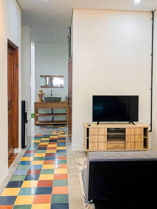 un soggiorno con TV e un pavimento colorato di SakaLoka Wirokerten Homestay a Gondowulung