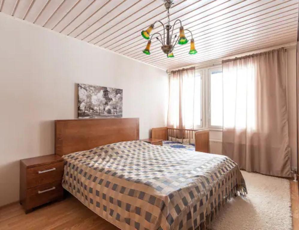 ロヴァニエミにあるVilla Repoのベッドとシャンデリアのある寝室