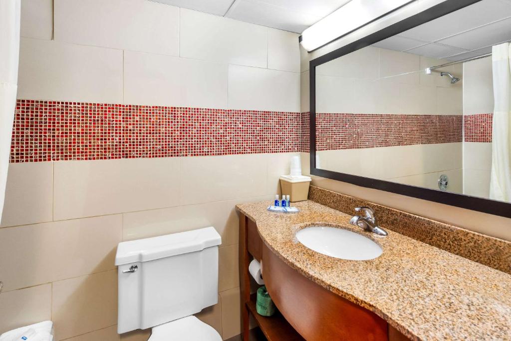 bagno con lavandino, specchio e servizi igienici di Rodeway Inn Capri a Little Ferry