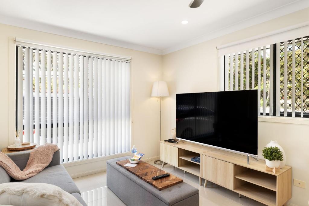 a living room with a large flat screen tv at Smart Suites Self Check-in Apartments - Sunnybank Station in Brisbane