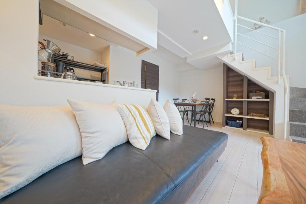 a living room with a couch with pillows at Pillowbook Accommodations Otaru Kaihoro 106 in Otaru