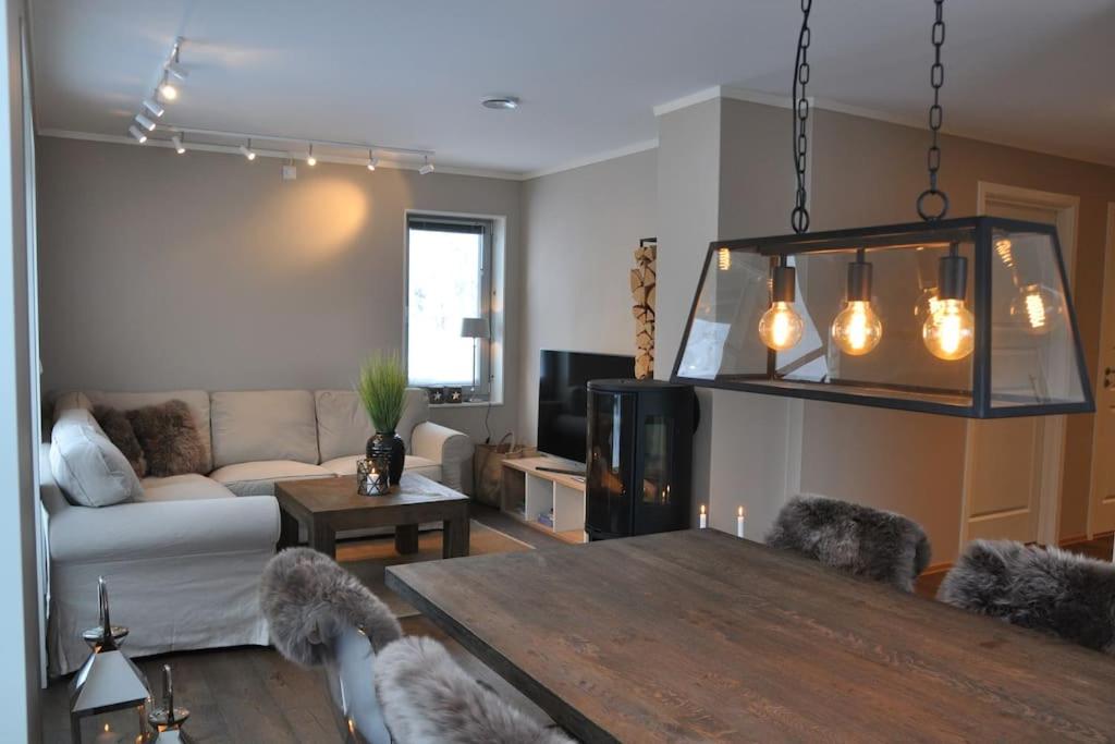 un salon avec une table et un canapé dans l'établissement Leilighet sentralt på Sjusjøen, 11 sengeplasser, à Ringsaker