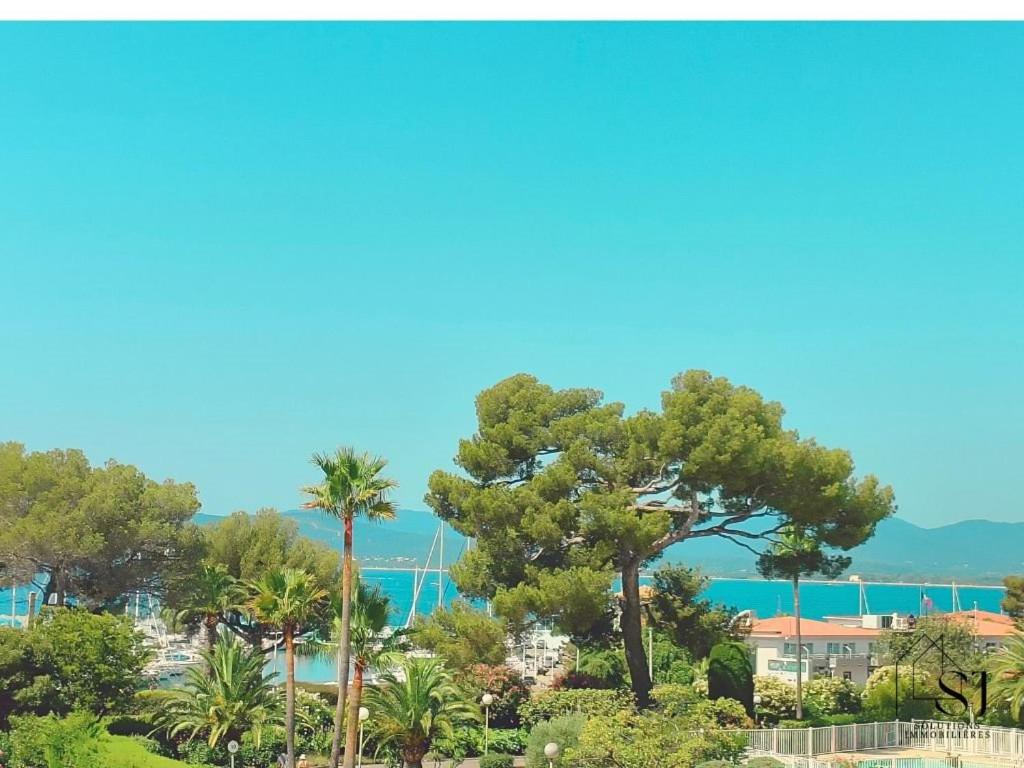 une vue d'un complexe avec des palmiers et l'océan dans l'établissement Très bel Appartement Le Santa Lucia à SAINT-RAPAËL - Confort, Climatisation et Vue mer !, à Ampuis