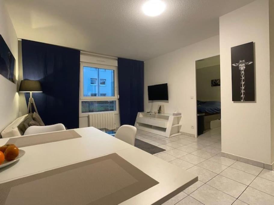 a living room with a table and a living room with a couch at T2 5 Lys - centre ville, parking privé in Saint-Louis