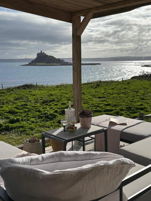 a table and chairs with a view of the ocean at The Tidal Shore - Adults Only - in Marazion