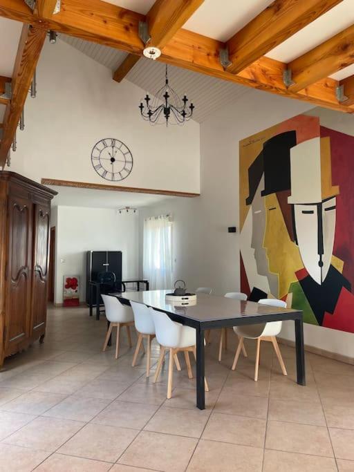 une salle à manger avec une table et des chaises et un tableau dans l'établissement Charmante Maison entre Castres et Lautrec, à Laboulbène