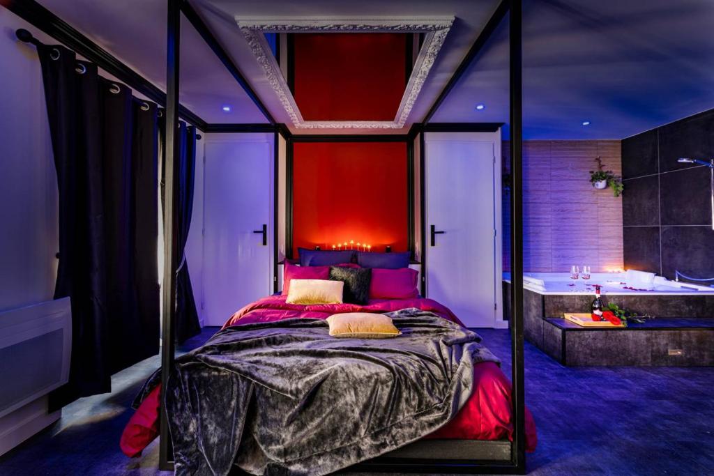 - une chambre avec un lit à baldaquin et une baignoire dans l'établissement Suite Jean Jaurès - Love Room, à Saint Etienne