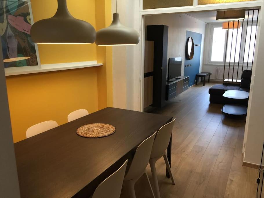 une salle à manger avec une table et des chaises noires dans l'établissement Maison spacieuse à la déco moderne, à Marcq-en-Barœul