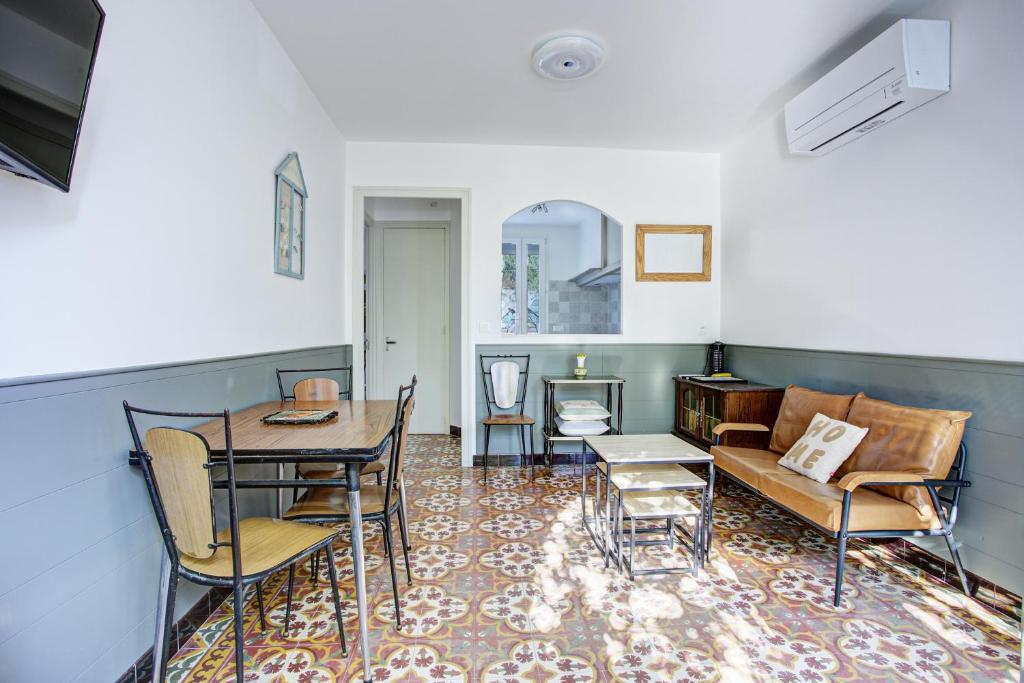 un salon avec un canapé, une table et des chaises dans l'établissement Mirande RDC - Appt à 1km de la plage avec jardin, à Port-Vendres