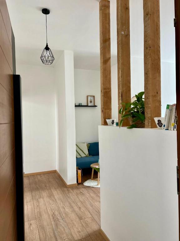 - un salon avec un mur blanc et un canapé bleu dans l'établissement Agréable T2, proche plage G, à Rosendaël