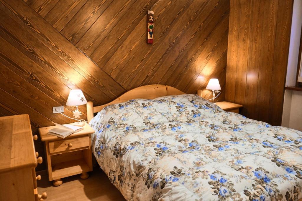 een slaapkamer met een bed en een houten wand bij Villa Antermont in Canazei