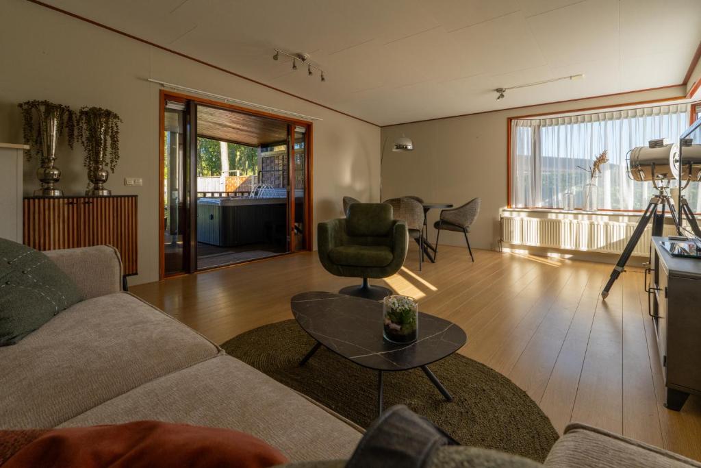 a living room with a couch and a table at Grasheide: Modern in Drenthe (4p) in Erm