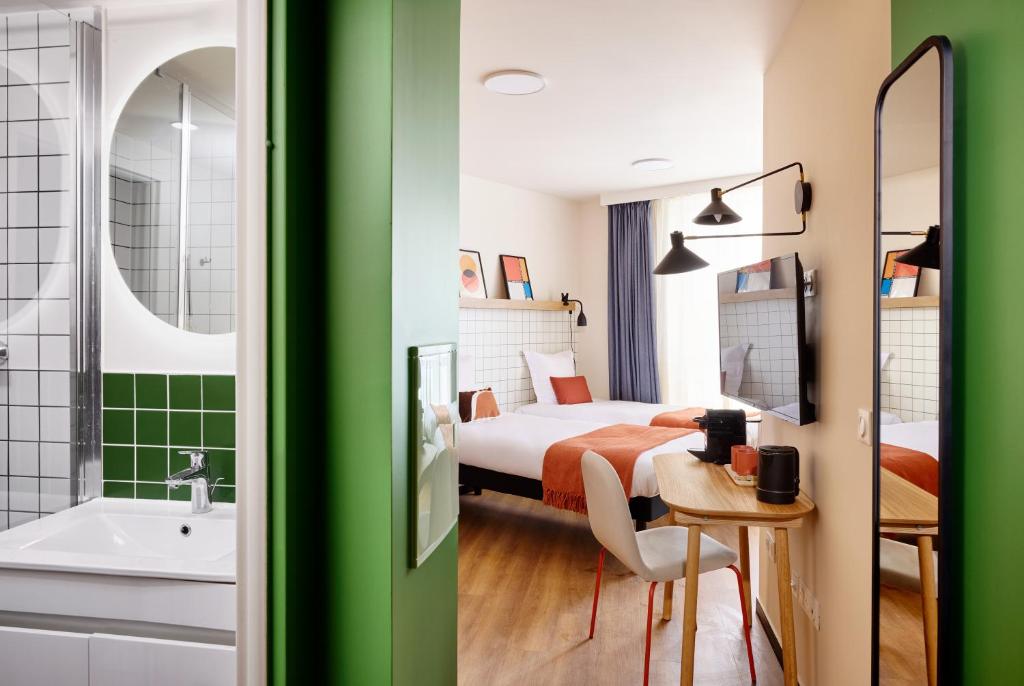 a hotel room with a bed and a bathroom at Hife Paris Issy Porte de Versailles in Issy-les-Moulineaux